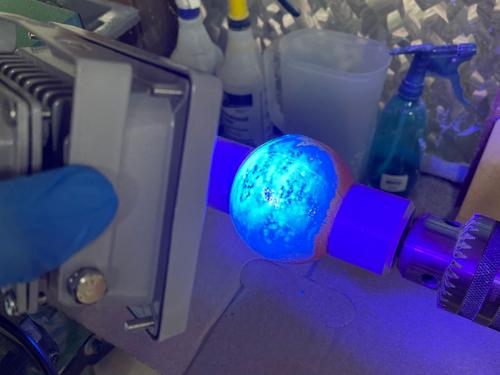 ultraviolet resin being cured onto the 3d printed ball